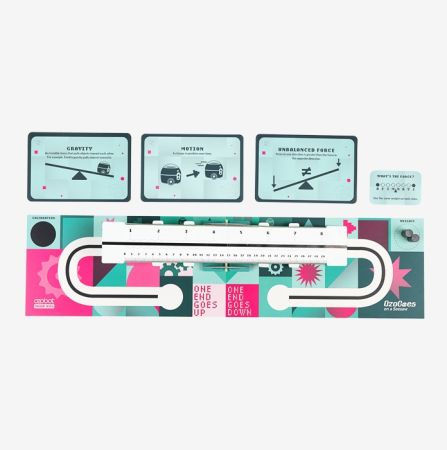 Open box view of the Ozobot OzoGoes Seesaw STEAM Kit, featuring illustrated instruction cards, colorful layout, and included seesaw component for STEM learning activities