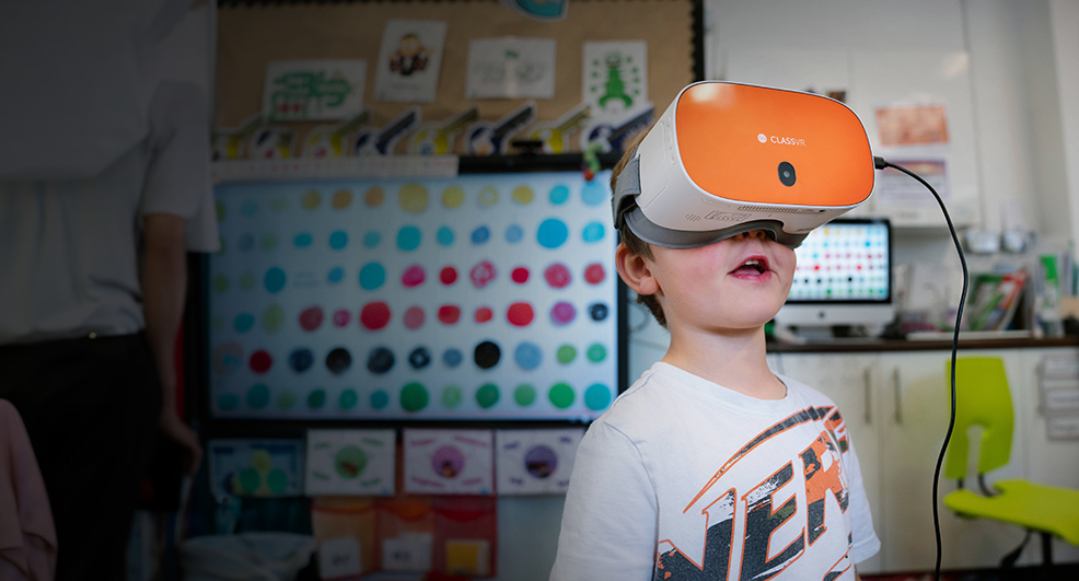 Young boy using ClassVR headset in a classroom for interactive learning. Atlab UAE offers VR education for schools